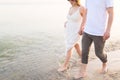 Outdoor shot of romantic young couple walking along the sea shore holding hands Royalty Free Stock Photo