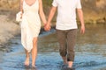 Outdoor shot of romantic young couple walking along the sea shore holding hands Royalty Free Stock Photo