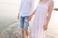 Outdoor shot of romantic young couple walking along the sea shore holding hands Royalty Free Stock Photo