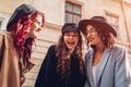 Outdoor shot of three stylish young women talking on city street. Friends laughing and having fun Royalty Free Stock Photo