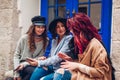 Outdoor shot of three young women looking at smartphone on the street. Girls talking and having fun Royalty Free Stock Photo