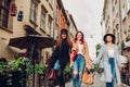 Outdoor shot of three young women walking on city street. Girls talking and hugging Royalty Free Stock Photo