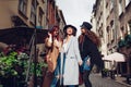 Outdoor shot of three young women walking on city street. Girls talking and hugging Royalty Free Stock Photo