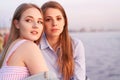 Pretty student girls enjoy sunset on a sea shore. Royalty Free Stock Photo