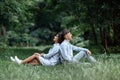 Outdoor shot of young happy couple in love sitting on grass on nature. Man and woman hugging, sunlight in summer park. Happy Royalty Free Stock Photo