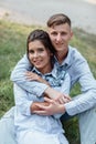 Outdoor shot of young happy couple in love sitting on grass on nature. Man and woman hugging, sunlight in summer park. Happy Royalty Free Stock Photo