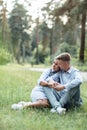 Outdoor shot of young happy couple in love sitting on grass on nature. Man and woman hugging, sunlight in summer park. Happy Royalty Free Stock Photo