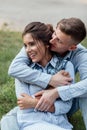 Outdoor shot of young happy couple in love sitting on grass on nature. Man and woman hugging, sunlight in summer park. Happy Royalty Free Stock Photo