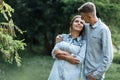 Outdoor shot of young happy couple in love on sunny day on nature. Man and woman hugging, sunlight in summer park. valentine`s da Royalty Free Stock Photo