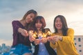 Happy group of asia girl friends enjoy and play sparkler at roof top party at evening sunset. Royalty Free Stock Photo