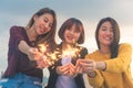 Outdoor shot of young people at rooftop party. Happy group of asia girl friends enjoy and play sparkler at roof top party. Royalty Free Stock Photo