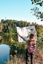 Outdoor shot of young slender backpacker being inspired by travelling, enjoying active rest, holding map, following trip way, good