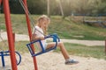 Outdoor shotof charming little girl on playground having fun at summer time,waiting for friend for playing, posing alone, cute