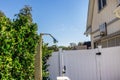 An outdoor shower near a backyard fenced swimming pool Royalty Free Stock Photo