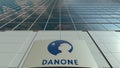 Signage board with Danone logo. Modern office building facade time lapse. Editorial 3D rendering