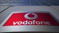 Outdoor signage board with Vodafone logo. Modern office building. Editorial 3D rendering