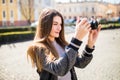 Outdoor smiling lifestyle portrait of pretty young woman having fun in the city in Europe with camera travel photo of photographer Royalty Free Stock Photo