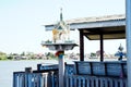 Outdoor spirit house on riverside local terrace in Thailand with garland and flowers in vases and some wreathes, joss house