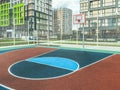 Outdoor sports. basketball court in a residential area. ball game next to tall glass houses. on the site a reliable anti-slip