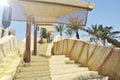 Outdoor stairway with a sun tent. In the background there are palm trees and fountain jets of water. A typical Arab lamp is Royalty Free Stock Photo
