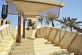 Outdoor stairway with a sun tent. In the background there are palm trees and fountain jets of water. A typical Arab lamp is Royalty Free Stock Photo