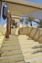 Outdoor stairway with a sun tent. In the background there are palm trees and fountain jets of water. A typical Arab lamp is Royalty Free Stock Photo