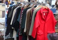 Outdoor stand on a flea market with used clothing and a red dres