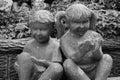 Black And White Portrait Of A Statue Of Two Children Reaching Out Their Palms