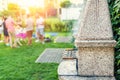 Outdoor stone stove with grill and skewers. Company of friends at barbecue party at park or backyard with green grass lawn and Royalty Free Stock Photo