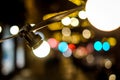 Outdoor string lights hanging on a line on street at night. Beautiful bokeh lights. Selective focus Royalty Free Stock Photo