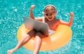 Outdoor summer business. Child remote working on laptop in pool. Little business man working online on laptop in summer