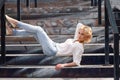 Outdoor summer fashion stunning portrait on pretty young blonde woman dressed in a white shirt and torn jeans having fun in t Royalty Free Stock Photo