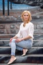 Outdoor summer fashion stunning portrait on pretty young blonde woman dressed in a white shirt and torn jeans having fun in t Royalty Free Stock Photo