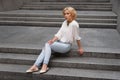 Outdoor summer fashion stunning portrait on pretty young blonde woman dressed in a white shirt and torn jeans having fun in t Royalty Free Stock Photo