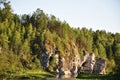 Outdoor summer landscape of the cliff, overgrown with trees by the lake. Royalty Free Stock Photo