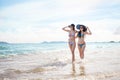 Outdoor summer portrait of the front image of two Asian beautiful girls in a sexy bikini standing on the beach in summer. teenage Royalty Free Stock Photo