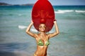 Outdoor summer portrait of slim beautiful woman with surfboard on a sunny beach
