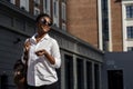 African american woman with backpack walking outdoor and talking on mobile phone Royalty Free Stock Photo