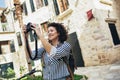 Pretty young woman having fun in the city in Europe in evening with camera Royalty Free Stock Photo