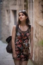 Outdoor summer smiling lifestyle portrait of pretty young woman having fun in the city in Europe with vintage analog camera. Woman