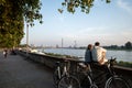 Couple sit and chill out on balustrade at Rheinuferpromenade along riverside of Rhine river in DÃÂ¼sseldorf, Germany.