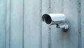 Outdoor surveillance camera fixed on rough concrete wall. Device monitors area for security. Modern tech secures premises and Royalty Free Stock Photo