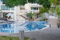 Outdoor swimming pool with handrails and many empty sunbeds at resort Royalty Free Stock Photo