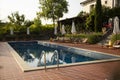 Outdoor swimming pool on the open air with beautiful view to the garden. Royalty Free Stock Photo