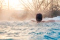 Outdoor swimming pool in winter with relaxing young woman