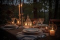 outdoor table setting with candles, plates, and silverware for romantic dinner Royalty Free Stock Photo