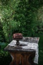 Outdoor table setting. Chocolate cake on a high wooden stand Royalty Free Stock Photo