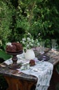 Outdoor table setting. Chocolate cake on a high wooden stand Royalty Free Stock Photo