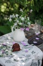 Outdoor table setting. Chocolate cake on a high wooden stand Royalty Free Stock Photo