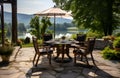 Outdoor terrace in front of the lake house with a round dining table for 4 people, breakfast or lunch in a cozy setting Royalty Free Stock Photo